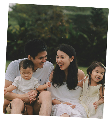 Family of four sitting together on a couch and smiling
