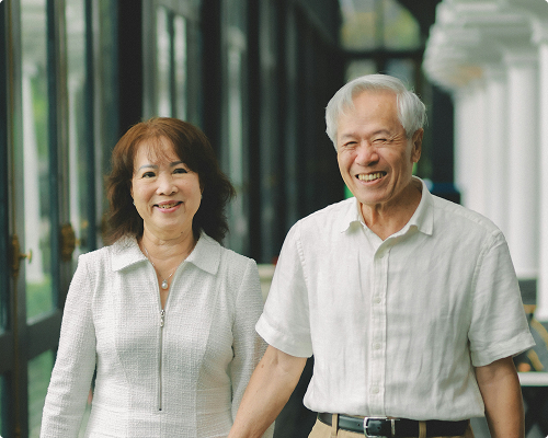 Older couple smiling warmly together in an outdoor setting